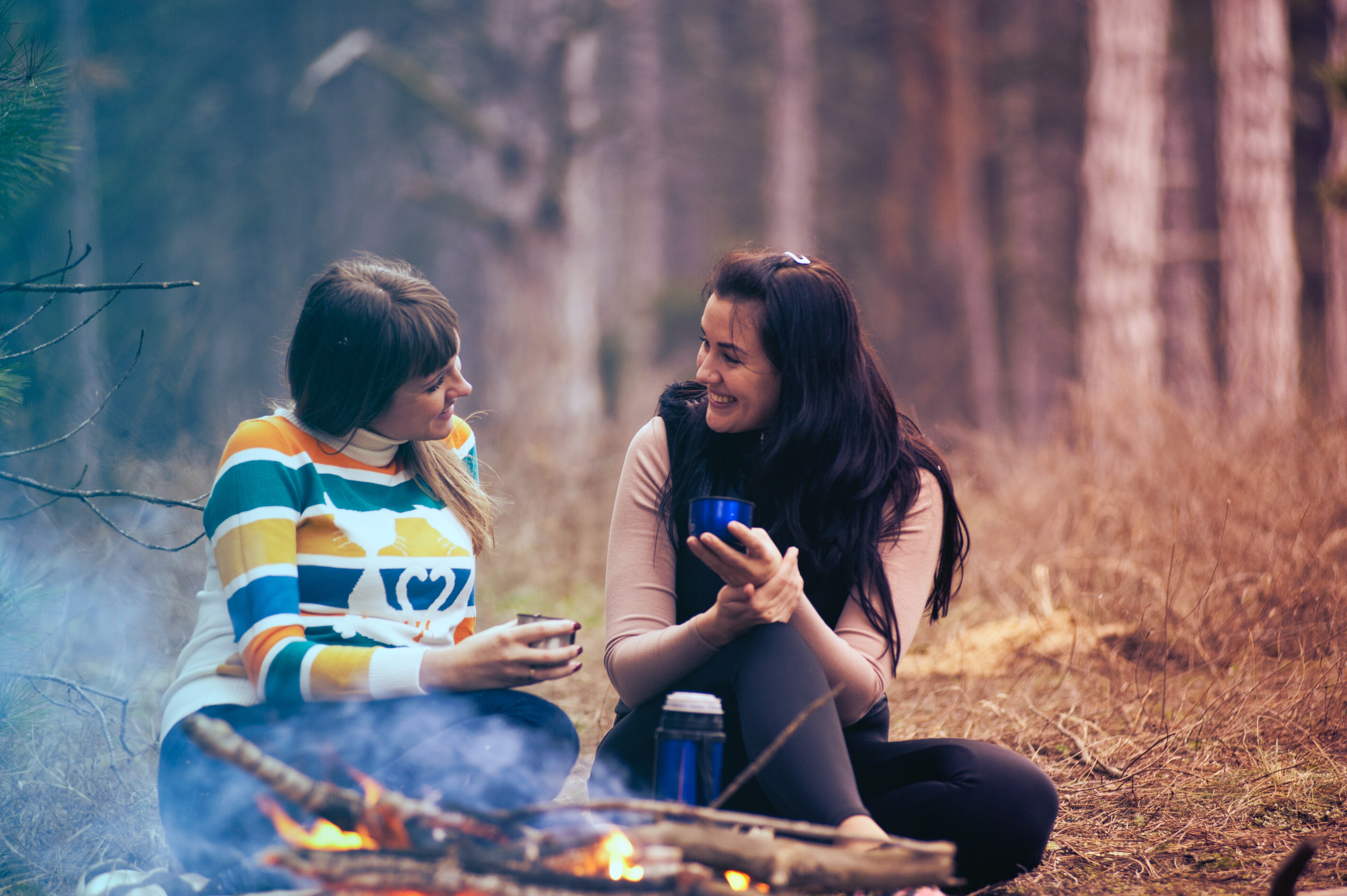 two women chatting round a camp fire